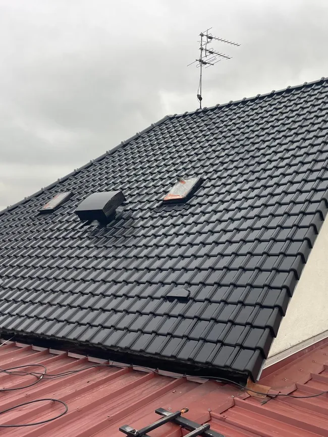 Toiture en tuiles avec fenêtres de toit, entretenue par ACBF