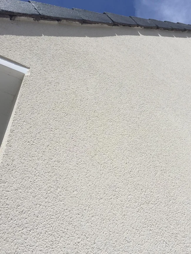 Gros plan sur l'enduit d'un mur réparé par ACBF